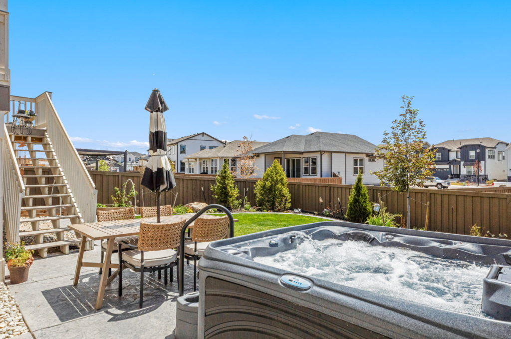 Backyard at 7991 Pennydale Drive in Sterling Ranch with covered deck, outdoor living space, and Pikes Peak views